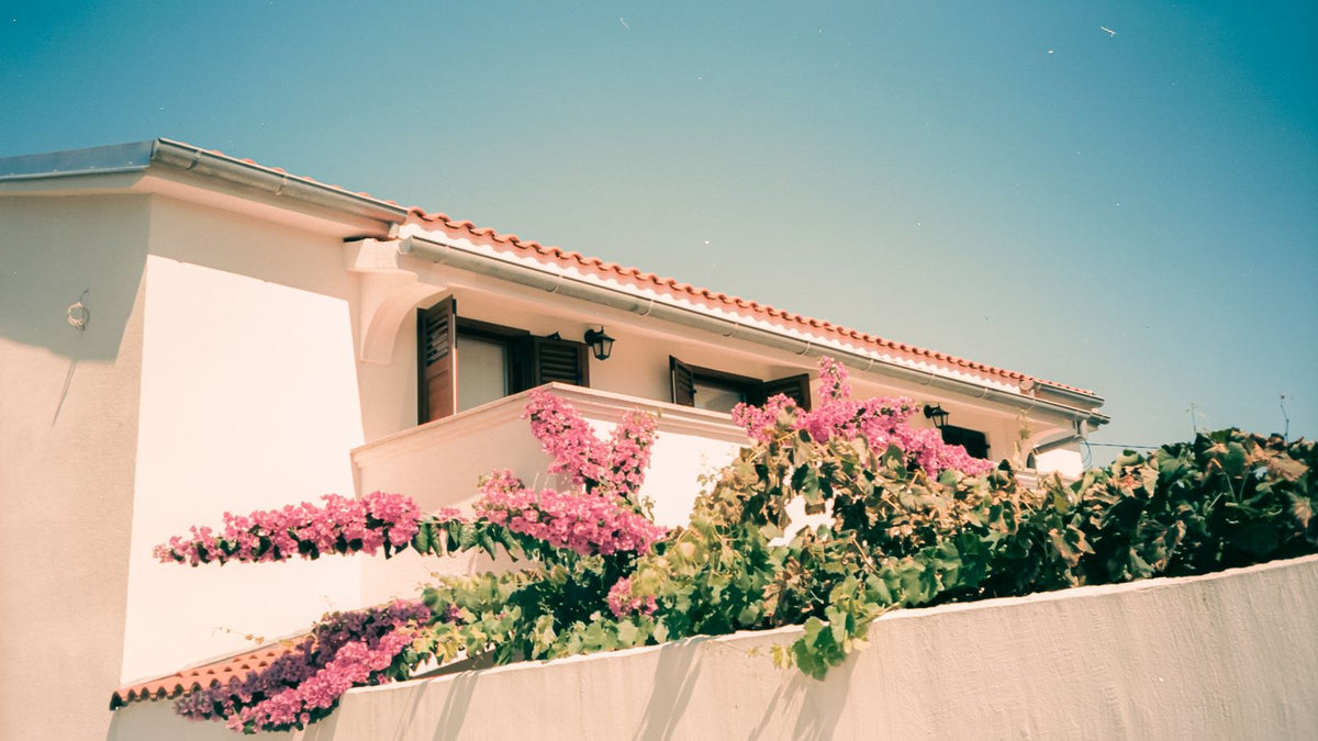 Maison méditerranéenne aux murs clairs fleurie de bougainvilliers