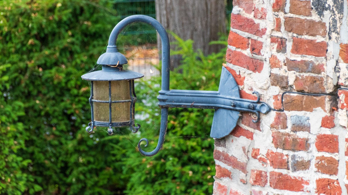Lanterne d'extérieur vintage fixée sur un mur de jardin