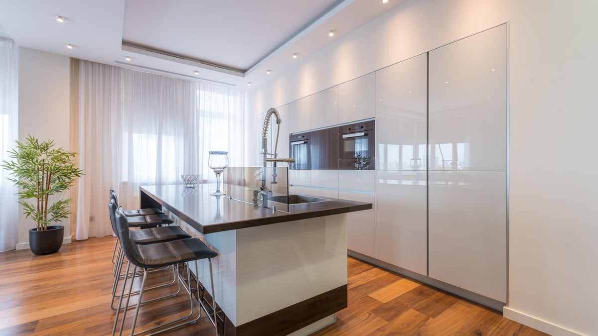 Cuisine blanche éclairée par des spots encastrés au plafond