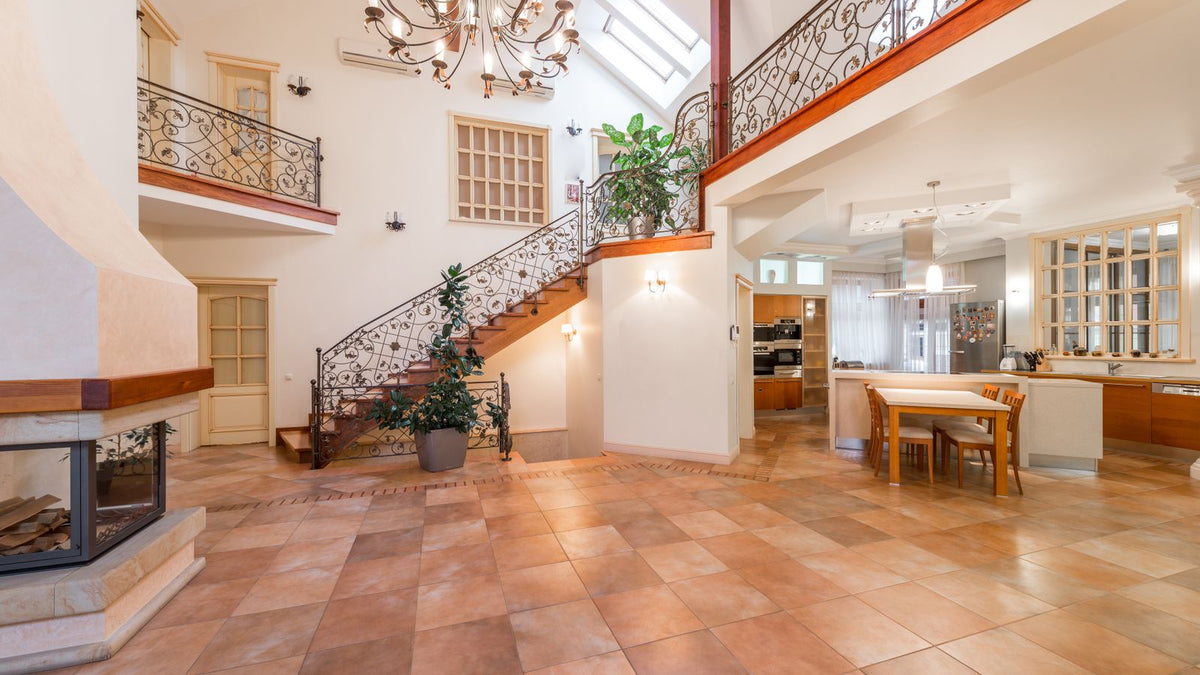 Grand volume sous verrière avec lustre et escalier, plafond très haut