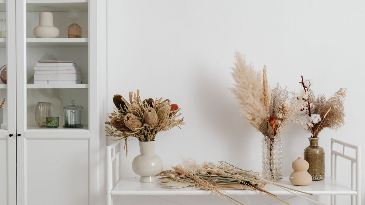 Étagère blanche ornée de fleurs séchées et d'herbes de la pampa