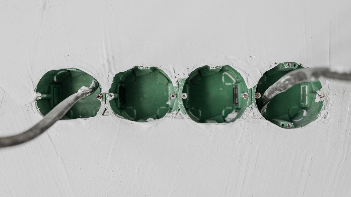 Boîtiers d'encastrement alignés dans un mur avant la pose des luminaires