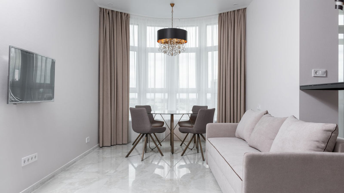 Salon blanc avec suspension noire au-dessus de la table