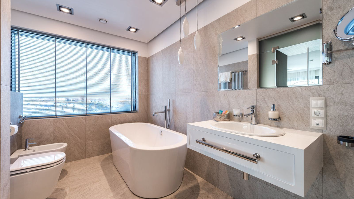 Salle de bain lumineuse avec baignoire, fenêtre et plafonnier encastré