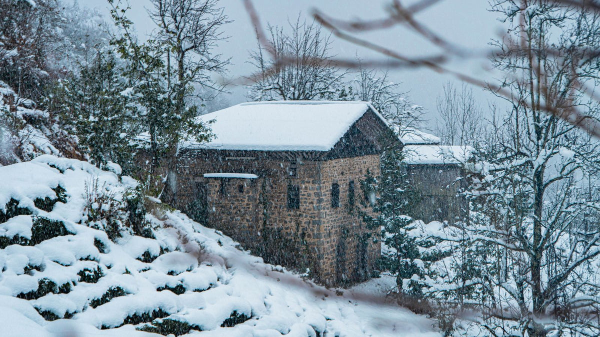 Maison en pierre sous la neige, façade exposée au gel