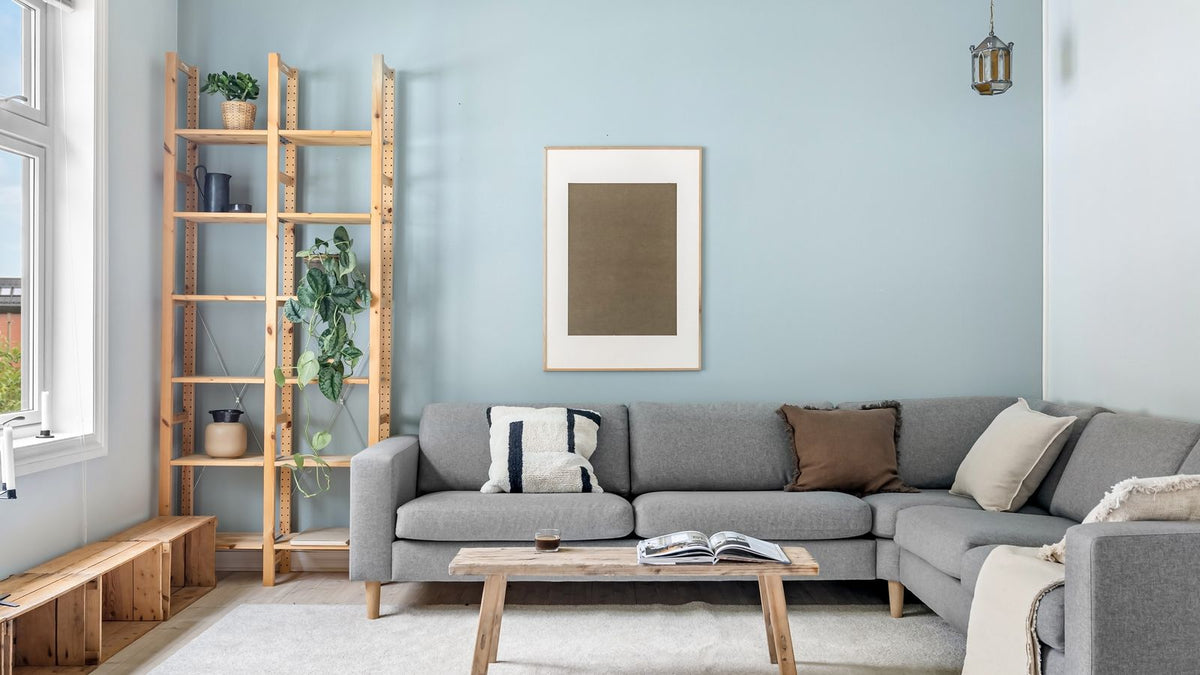 Salon scandinave au canapé gris, bois clair et lumière chaude
