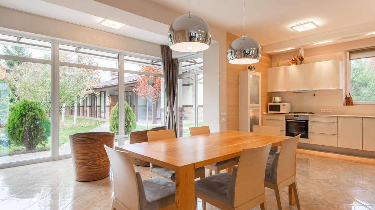 Salle à manger lumineuse avec suspensions design au-dessus de la table