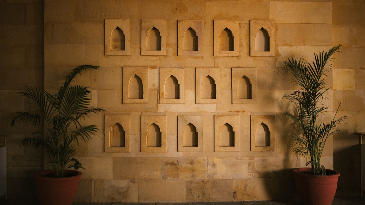 Mur de niches en pierre beige éclairé par une lumière chaude