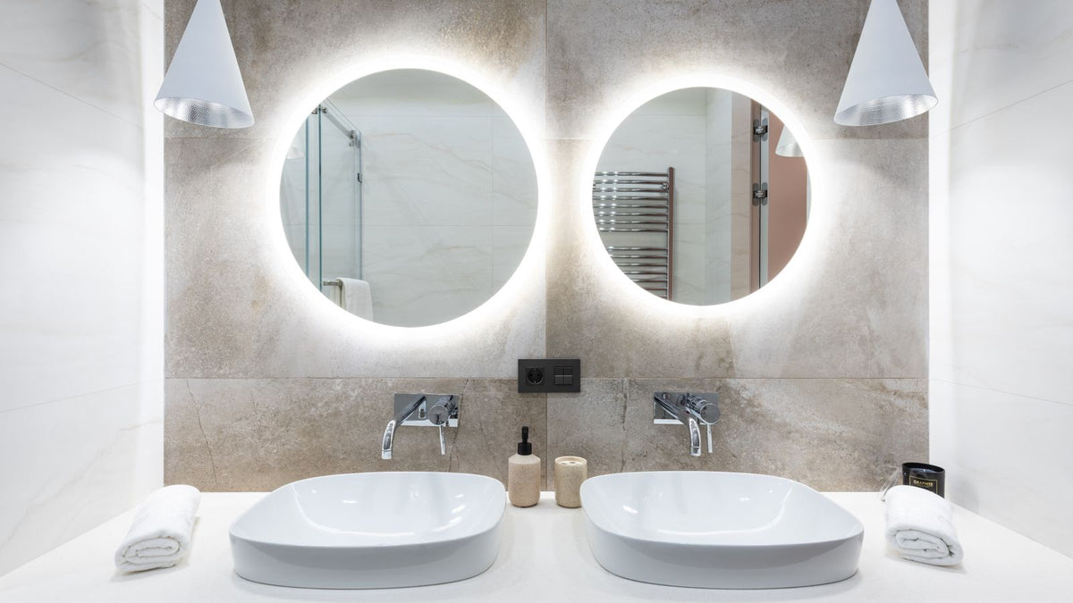 Salle de bain avec deux miroirs ronds rétroéclairés au-dessus des vasques