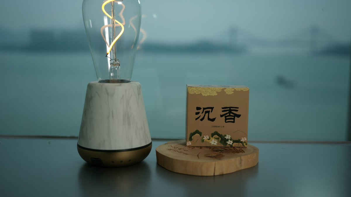 Ampoule décorative allumée près d'une bougie parfumée, lumière chaude du soir