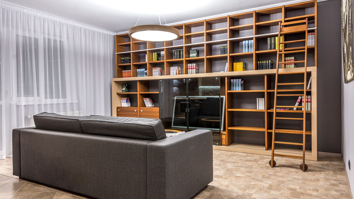 Salon avec grande bibliothèque murale en bois bien éclairée