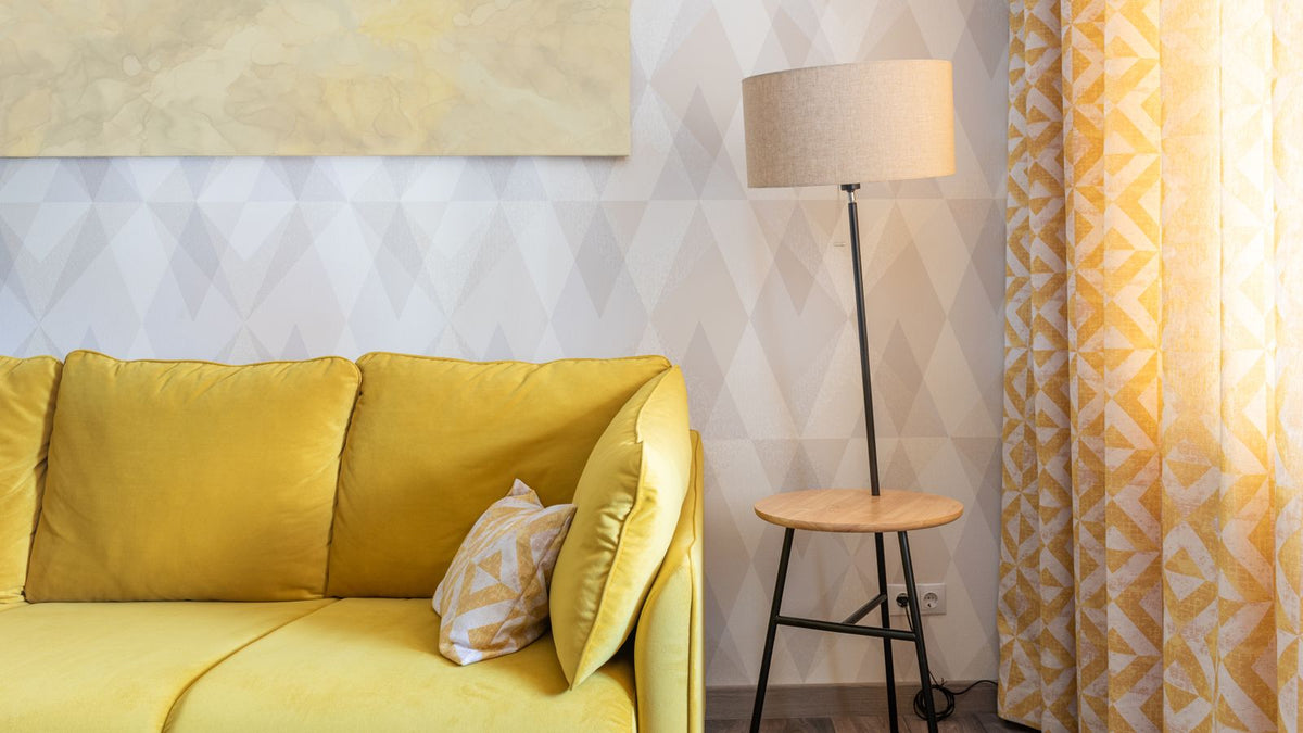 Lampadaire à côté d'un canapé jaune dans un salon lumineux