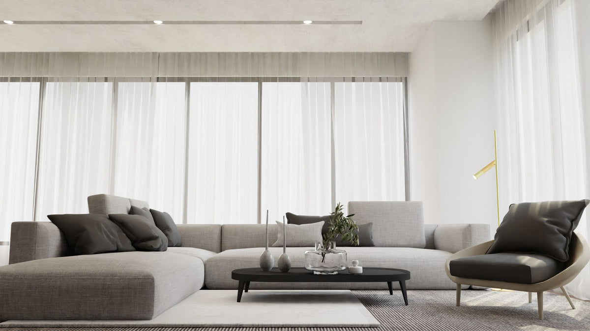 Salon minimaliste baigné de lumière avec canapé gris et table basse