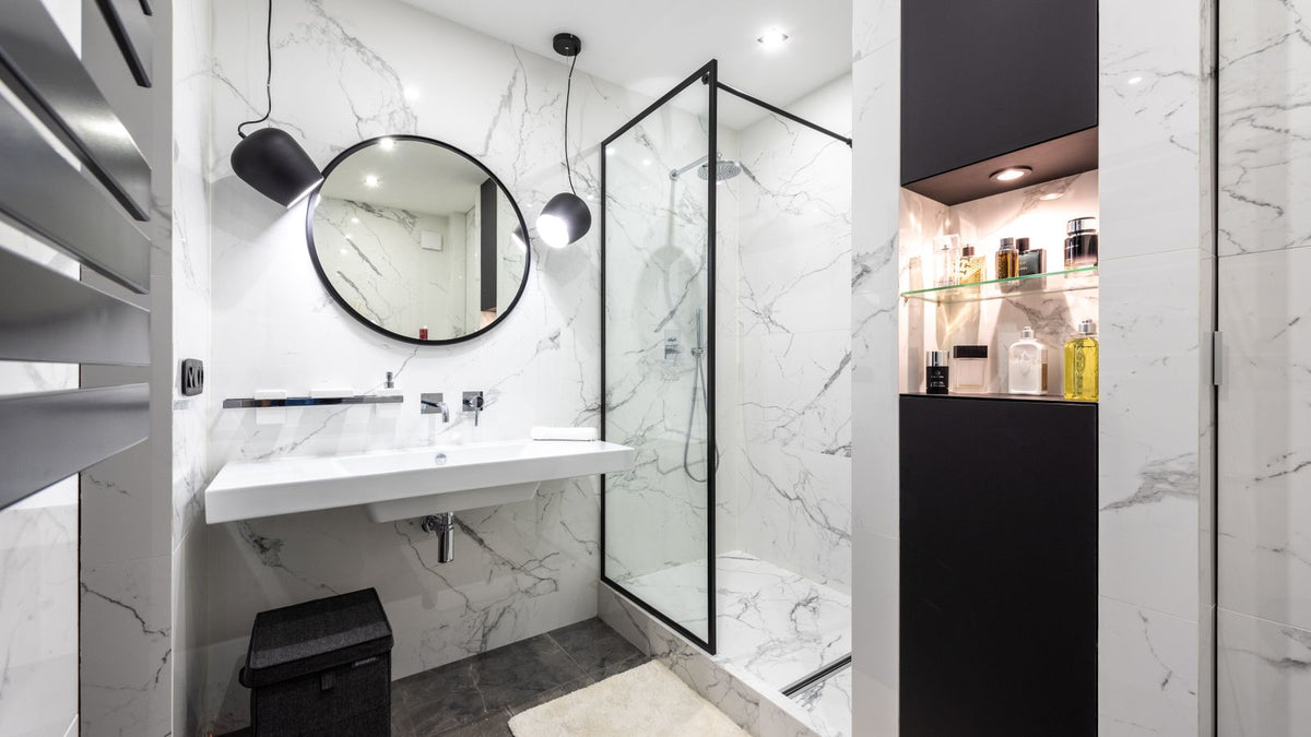 Petite salle d'eau en marbre avec suspensions et miroir rond