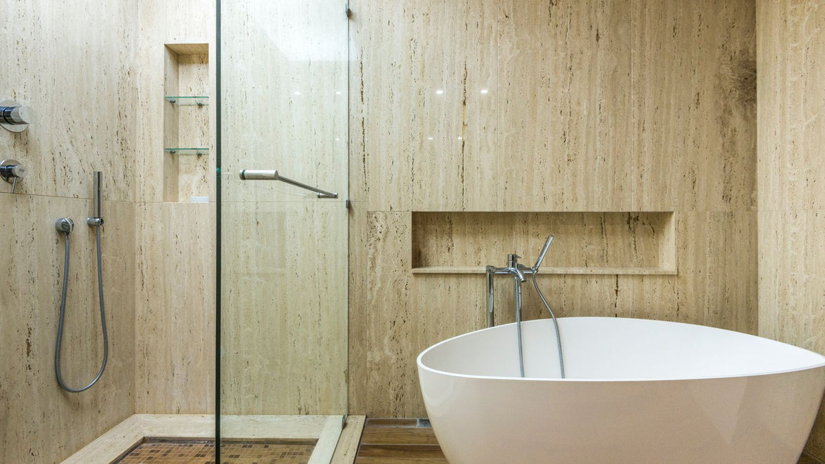 Salle de bain en pierre beige finition adoucie avec baignoire îlot