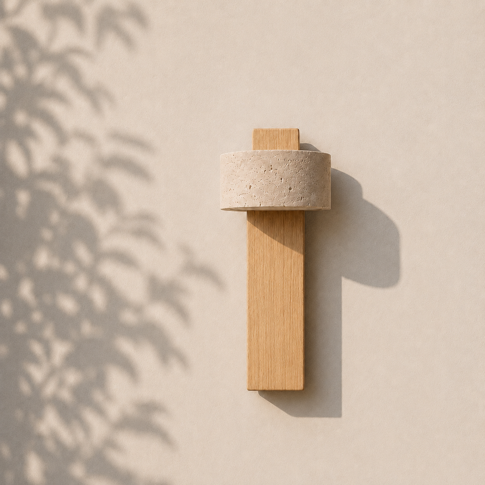 Applique travertin et bois clair éteinte en journée, ombres de feuillage sur mur en stuc #bois-clair