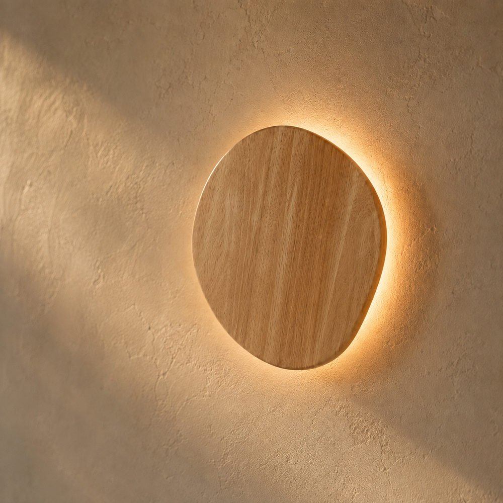 Applique galet en bois nordique allumée, anneau de lumière sur un mur en enduit crème #ovale