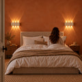 Deux appliques en travertin de chaque côté d'une tête de lit, chambre terracotta, lecture du soir