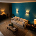 Salon vu d'en haut : deux appliques en travertin au-dessus d'un canapé en lin, mur bleu canard