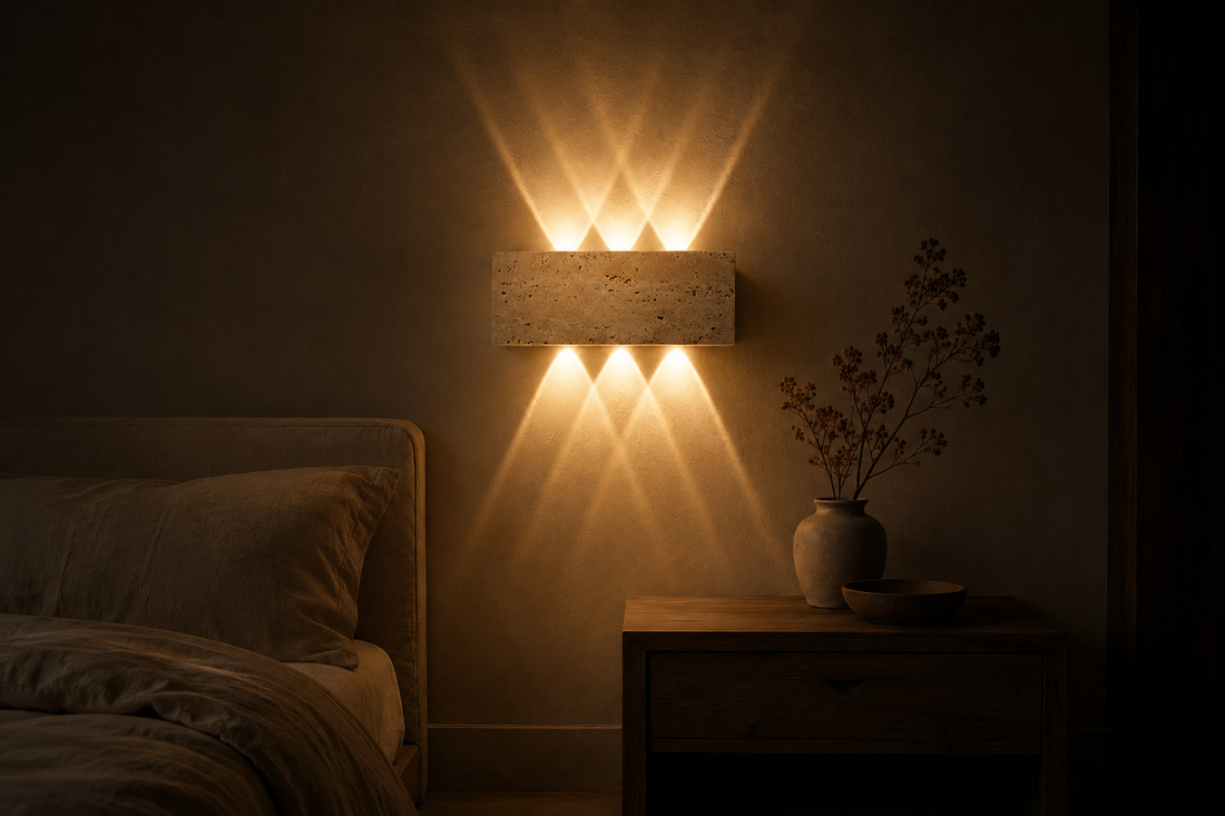 Chambre dans le noir, l'applique en pierre est la seule source allumée et projette deux éventails sur le mur