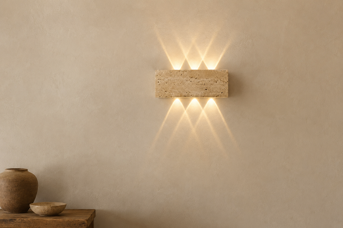 Mur à la chaux crème révélé par les deux éventails de lumière de l'applique en pierre