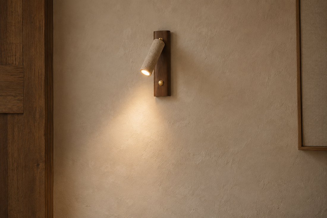 Mur à la chaux crème révélé par la lumière rasante de l'applique en travertin