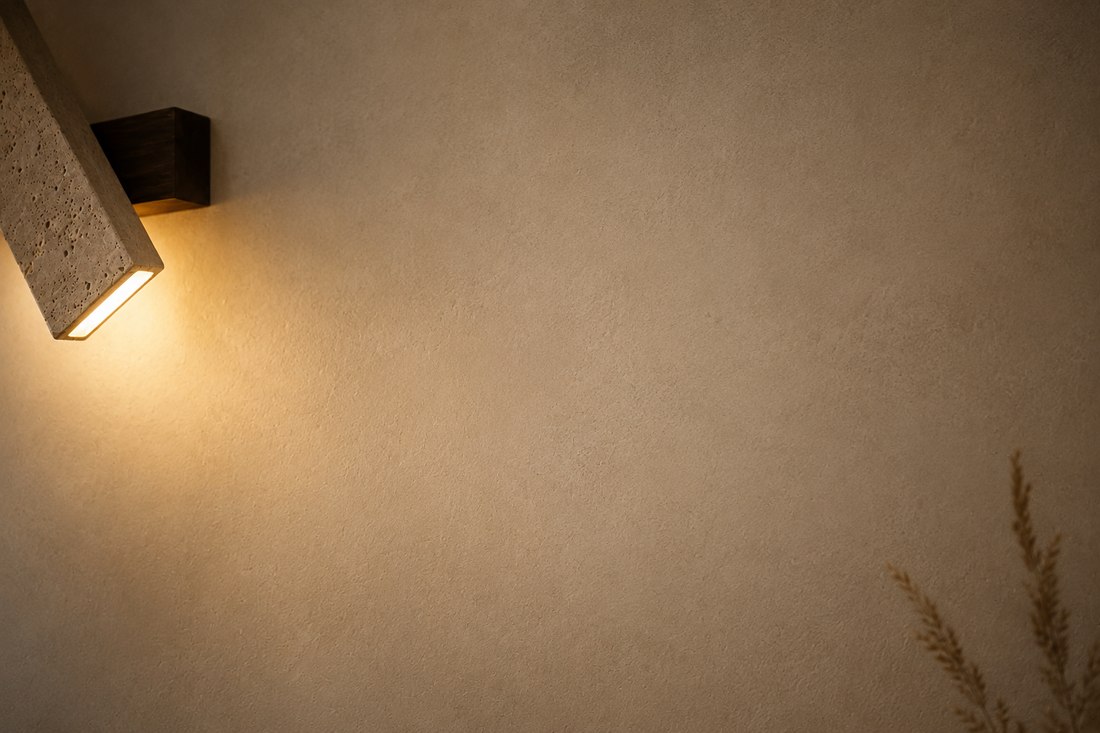 Mur à la chaux crème révélé par la lumière rasante de l'applique en pierre naturelle